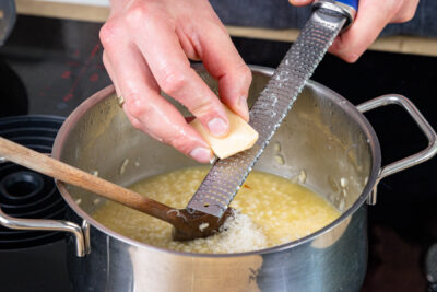 Grana Padano ins Risotto alla Milanese reiben