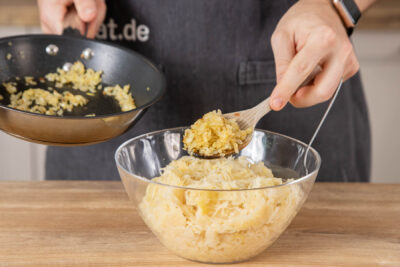Sauerkraut und Zwiebeln vermengen