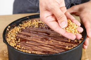 gehackte Nüsse über dem schnellen Kuchen ohne Backen verteilen