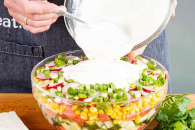 Joghurt-Dressing über den Salat geben