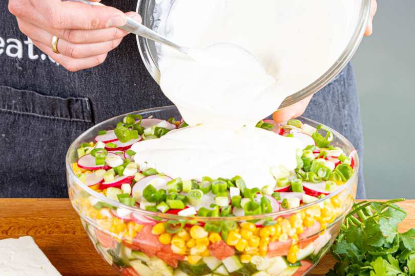 Joghurt-Dressing über den Salat geben