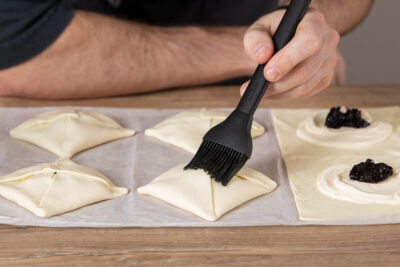 Gefüllte Blätterteigtaschen bestreichen
