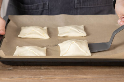 Blätterteigtaschen auf einem Blech verteilen