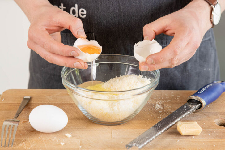 Ei und Parmesan vermengen