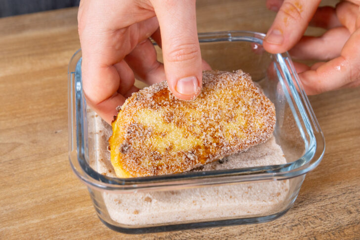 Gebackene Zwetschgenbavesen in Zucker und Zimt wälzen.