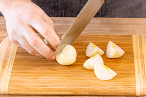 Zwiebeln und Knoblauch schälen und vierteln