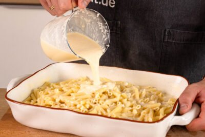 Soße über die Pasta gießen
