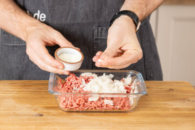 Hackfleisch und Zwiebeln salzen