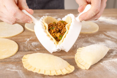 gefüllte Teigkreise zusammenfalten und Empanadas verschließend