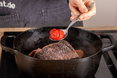 Tomatenmark in den Bräter geben