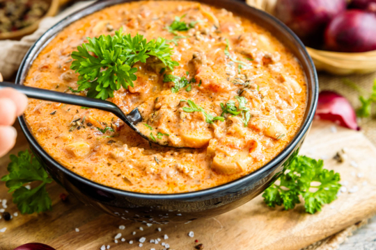 Friss-dich-dumm-Suppe mit Petersilie garnieren