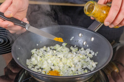 Currypulver in die Pfanne geben