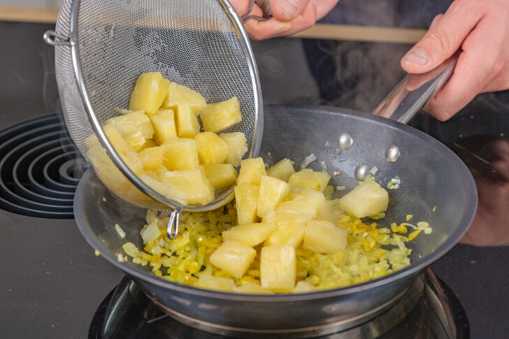 Ananas in die Pfanne geben