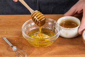 Honig in die Schüssel zum Dressing geben