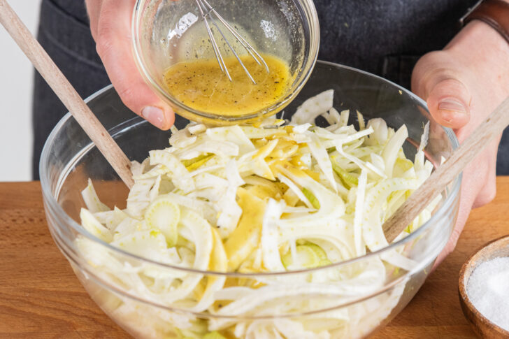 Dressing und Fenchelstreifen vermischen