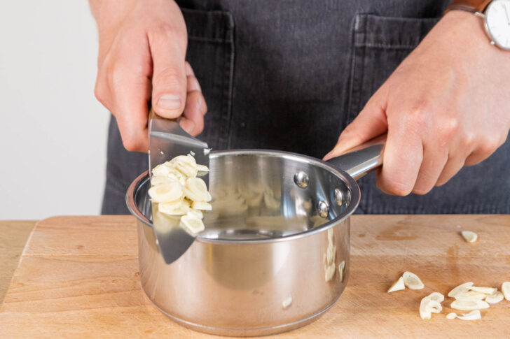 Knoblauch in einen Topf geben