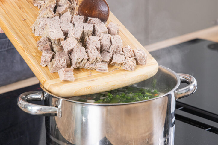 gekochtes Rindfleisch in den Topf geben