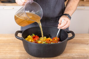 Gemüsebrühe zur Ofensuppe gießen