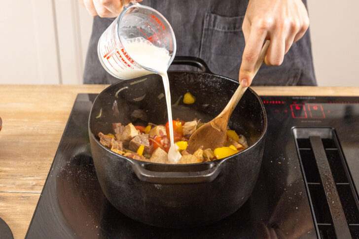 Sahne zum Gemüse und Fleisch gießen