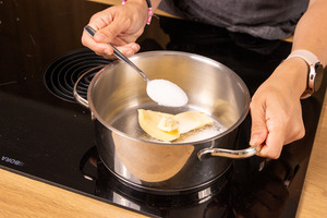 Zucker zur Butter in den Topf geben