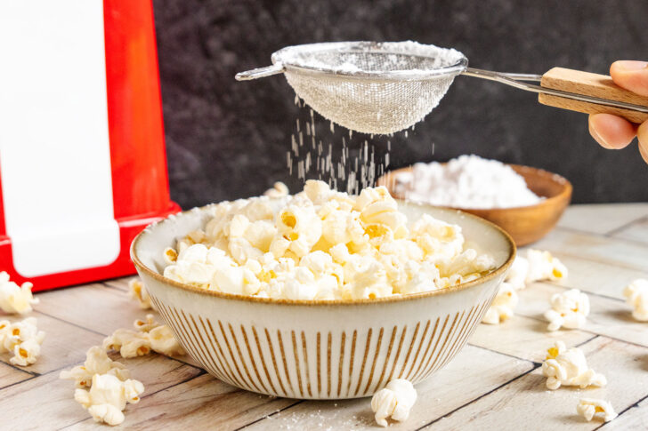 Popcorn aus der Maschine mit Puderzucker süßen