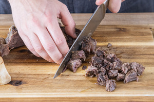 das gegarte Rindfleisch in mundgerechte Stücke schneiden