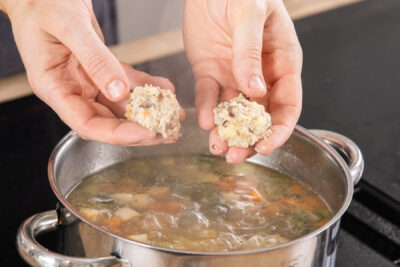 Die Markklößchen in die Rindfleischsuppe geben