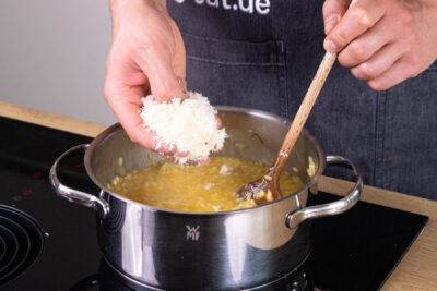 Parmesan unter das Safranrisotto heben