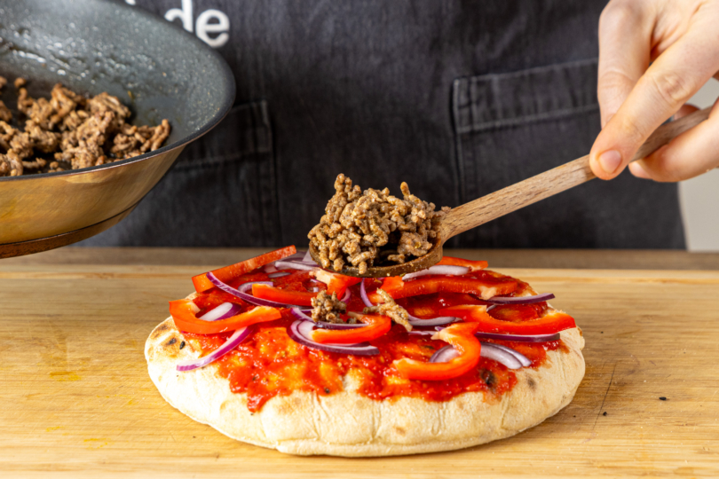 Hackfleisch auf Fladenbrot verteilen