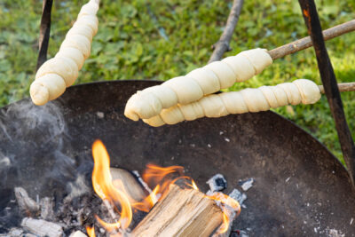Stockbrot über dem Feuer garen