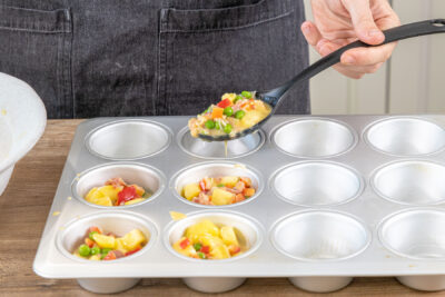 Tortilla-Muffins Masse in Förmchen füllen