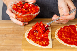 Tomatenstücke auf Tortilla geben