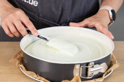 Frischkäse-Creme auf dem Kuchen verteilen