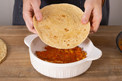 Die Tortillas abwechselnd mit der Hackfleischmasse einschichten.