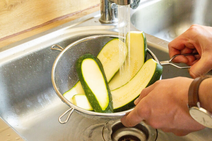 Zucchinischeiben abspühlen