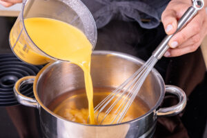 aufgelöstes Puddingpulver in aufgekochtem Apfelsaft einrühren