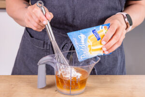Puddingpulver mit Zucker in Apfelsaft auflösen