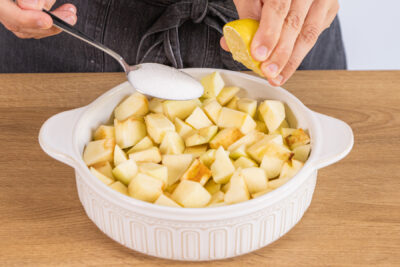 Zucker und Zitronensaft zu den Äpfel geben