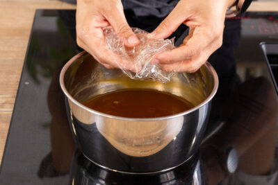 Gelatine zur Marmelade in den Topf geben