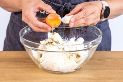 Ei zur Cheesecake-Masse geben