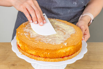 Puddingcreme auf Biskuitboden verstreichen
