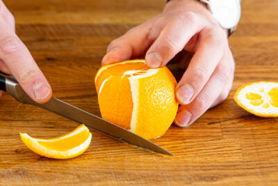 Orange mit dem Messer schälen