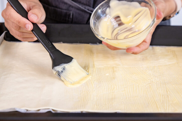 Blätterteig mit Butter bestreichen