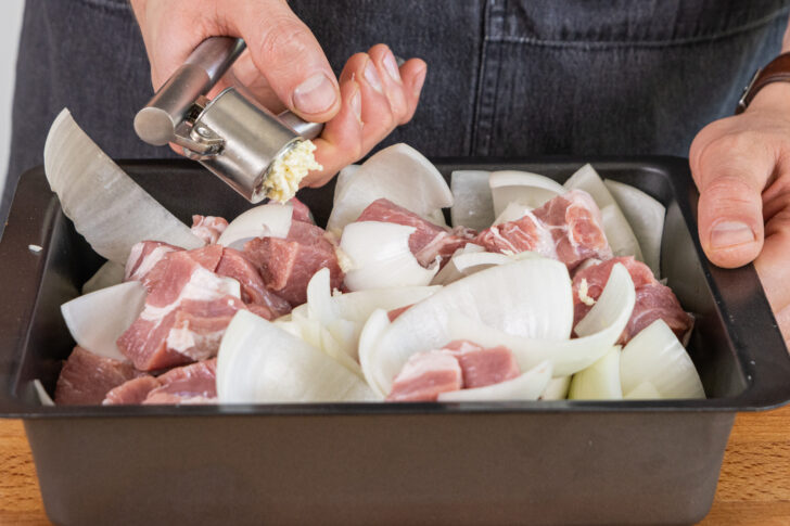 Knoblauch in die Auflaufform pressen