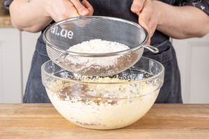 Puderzucker und Backkakao zur Butter sieben