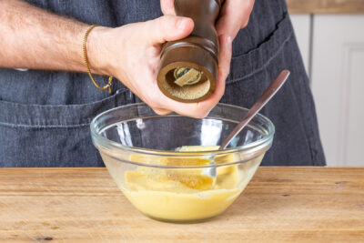 Senf-Honig-Dill-Sauce mit Pfeffer würzen