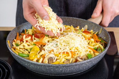 Käse zur Spätzlepfanne geben