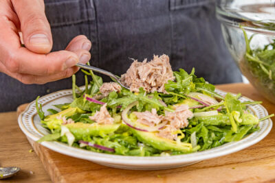 Thunfisch auf dem Salat verteilen