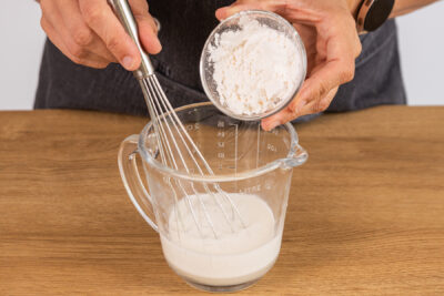 Puddingpulver und Zucker in etwas Milch auflösen