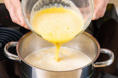 angerührtes Puddingpulver zur Hafermilch in den Topf geben